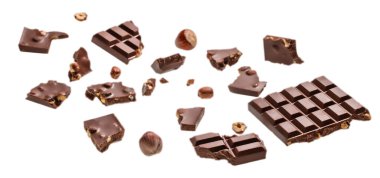 Beyaz arka planda fındıklı çeşitli kırık sütlü çikolata parçaları..