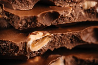 Sıcak yakın çekim kompozisyonu katmanlı kırık sütlü çikolatanın makro dokusu birinci sınıf şekerleme reklamcılığı, tatlı markalaşması, ambalaj tasarımı için ideal..