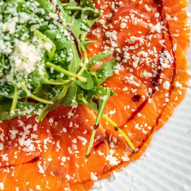 Taze roka soslu somon carpaccio, rendelenmiş peynir ve balzamik jöle, zengin desenli restoran menüsü, aşçılık markası..