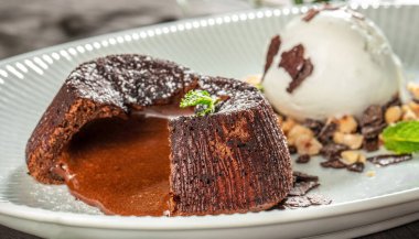 Vanilyalı dondurma, fındık ve çikolatalı gevrek, gurme tatlı menüsü, markalaştırma ve kaliteli yiyeceklerle servis edilen erimiş, zengin çikolatalı lav keki..