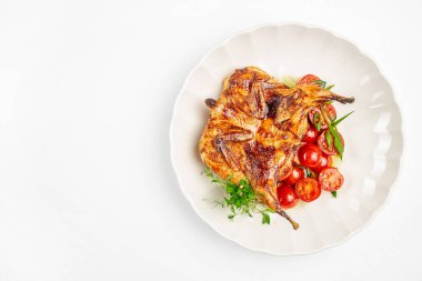 Beyaz tabakta servis edilen kiraz domatesli ızgara bıldırcın ve taze otlar, fotokopi alanı reklamları ve menü tasarımı..