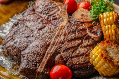 Kömürleşmiş mısır ve kiraz domatesli sulu ızgara biftek. Tereyağlı sos, restoran menüleri, reklam ve kaliteli markalaştırma ile servis ediliyor..