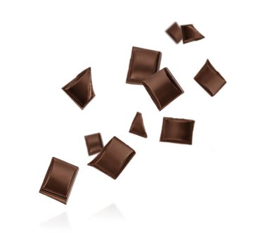 Siyah çikolata kareleri havada çekildi ve beyaz zemin üzerinde bir sürü kopya alanı ile izole edildi. Reklam, markalaşma, ambalaj ve modern tasarım projeleri için temiz ve dinamik bir gıda konsepti yarattı..