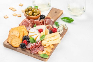 Peynir, jambon, salam, zeytin, kraker, incir ve böğürtlenli nefis antipasto tabağı, şarap tatma, ikram ve gurme yemek kavramları için idealdir.