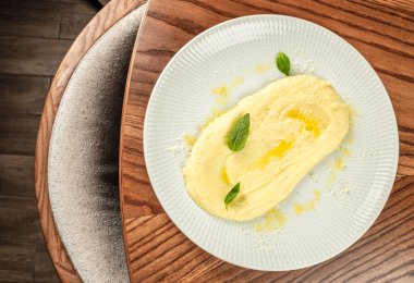 Kremalı patates püresi, tereyağlı zeytinyağı ve fesleğen, ahşap masa, üst manzara, kopyalama alanı.