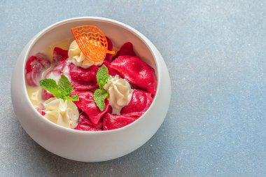 Parlak pancar mantı, kremalı sos ve hafif arka planda taze nane şekeri ile servis edilir. Gurme restoran menü, reklam ve yiyecek markalaştırma konsepti.