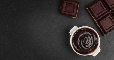 Siyah desenli arka planda çikolata parçalı siyah çikolata sosu. En üstteki daire. Tatlı reklamları ve yemek tasarımı için fotokopi alanı var.