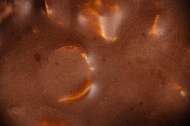 Doğal kakao dokusuna sahip pürüzsüz sütlü çikolata yüzeyi, ambalaj, reklam ve tasarım için uygun soyut gıda arkaplanı Makro yakın çekim.