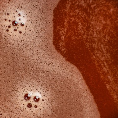 Baloncuklu sıcak çikolata köpüğü ve zengin kakao dokusuyla makro yakın plan, reklam, ambalaj ve tasarım için uygun soyut içecek arka planı.