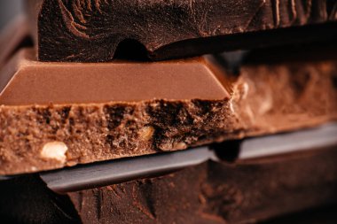 Katmanlı koyu ve çikolata parçalı fındık dolgulu Macro. Zengin kakao dokusu ve yiyecek reklamları, ambalajları ve markalaşma için tatlı arkaplanı..