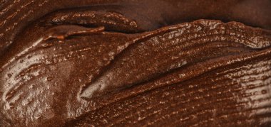 Makro görüntüde çikolatalı krema dokusu. Pürüzsüz kremalı kakaolu zengin kakao. Yemek tasarımı, tatlı reklamları, ambalajlama, markalaşma, afişler ve arka planlar için mükemmel..