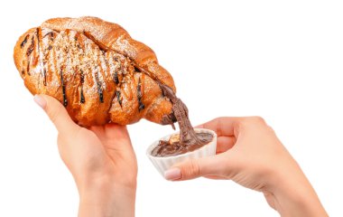 Karamel ve çikolata kaplı kruvasanı kremalı çikolataya batıran kadın, beyaz arka planda izole edilmiş..