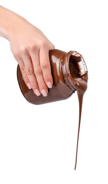 Kalın, parlak çikolata, kadın eli tarafından tutulan cam kavanozdan akan uzun bir akarsu, zengin tatlı konsepti, beyaz üzerine izole edilmiş.