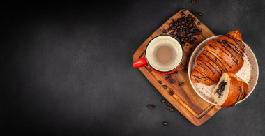 Koyu dokulu arka planda kahve ve kahve çekirdekli çikolatalı kruvasanlar, reklam için fotokopi alanı, menü ve fırın markalaştırma için üst görünüm kompozisyonu.