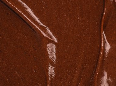 Pürüzsüz organik akış çizgilerine ve parlak kahverengi yüzeyine sahip zengin çikolata yayılmış doku, markalaşma, paketleme, pankart ve gıda tasarımı için doğal zarif arkaplan.