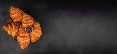 Çikolatalı kruvasan ve siyah arka planda sepetin içinde cips, fotokopi alanı olan en iyi manzara fırın afişi..