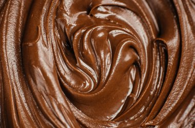 Pürüzsüz, parlak çikolatayı kapayın. Bol kıvrımlı dokusuyla. Lezzetli tatlı arkaplanı yemek tasarımı, ambalaj ve reklam için idealdir.
