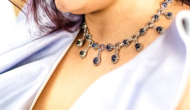 Lüks ve güzel mavi ve gümüş safir kolyenin ayrıntıları beyaz bir kadının boynunda.