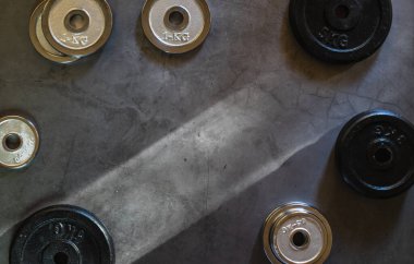 Beton bir yüzey üzerinde farklı ağırlık, boyut ve renklerde boş alan içeren ağırlık levhaları