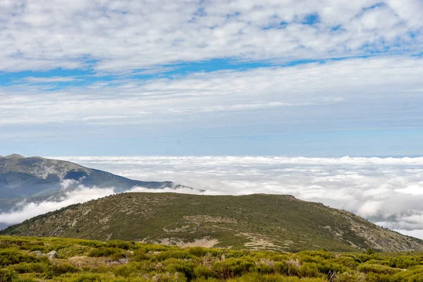 Beautiful sea of clouds from a mountain on a sunny day. Low clouds in the Sierra de Guadarrama, Madrid.