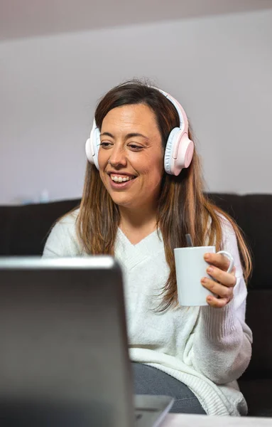 Young Woman Using Her Laptop Wireless Headphones Holding Cup Sofa — Stock Photo, Image