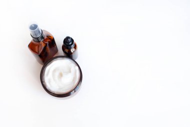 Kavanozda sıvı kozmetik serumu ve krema için kahverengi cam şişe.