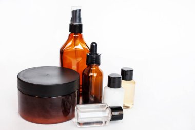 Kahverengi ve şeffaf plastik şişe sıvı kozmetik serumu ve krema için kavanozda.