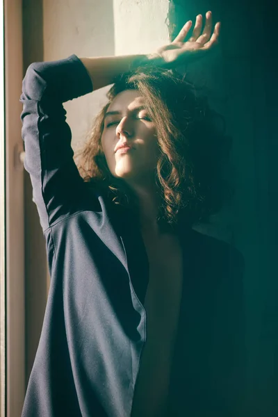 Сексуальная девушка в пиджаке на обнаженном теле, сидящая на подоконнике — стоковое фото