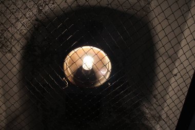 Tavandaki elektrik lambası acil durum ışıklarını yakıyor.