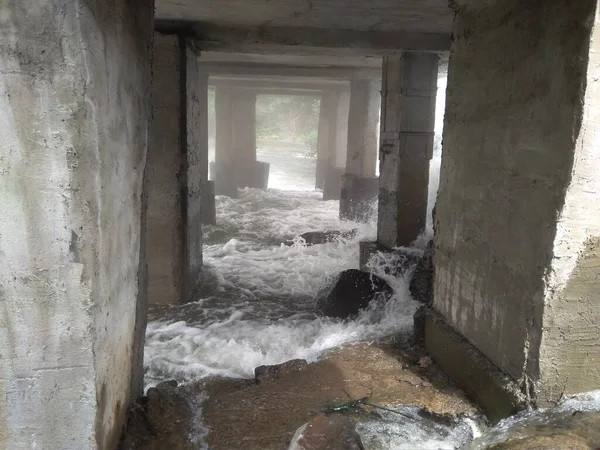 Su, baraj kazasının bodrumundaki şelaleden aşağı akıyor.