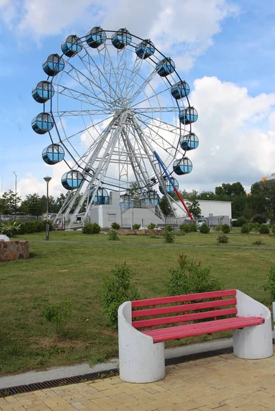 Una Panca Vuota Nel Parco Con Attrazione Della Ruota Panoramica — Foto Stock