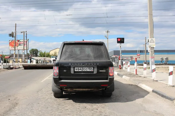 Rusya, Novosibirsk, 22.07.2020: Demiryolu geçidinde durdurulan bir araba semafor sinyalini yasakladı.