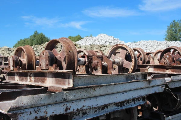 old broken wheels of a metal trolley in a junkyard wagons