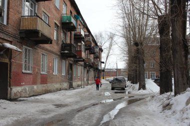 Rusya, Novosibirsk 15.03.2020: İlkbaharda kentte park halindeki evin girişindeki su birikintileri yayalar için kirli.