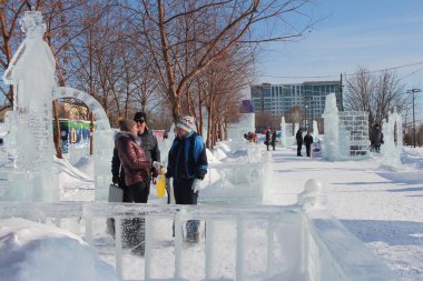 Rusya, Novosibirsk 07.03.2021: kış yürüyüşünde parktaki insanlar tatildeki buz heykellerinde mutlu iletişim kuruyorlar
