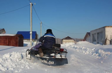 Rusya, Novosibirsk 12.02.2021: bir adam kışın Sibirya 'da bir köyde kar aracına biniyor