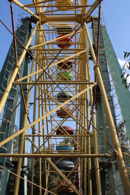 Parktaki dönme dolaba metal çekim. Sandalyeli yüksek atlıkarınca.