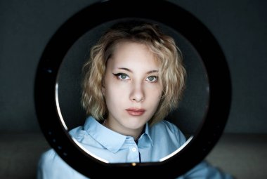 Karanlıkta yuvarlak lambayla internette çalışan blogcu bir kızın portresi. Kapalı