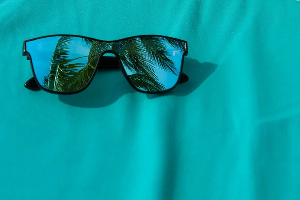 선글라스가 해변의 청록색 직물에 야자나무를 감상하는 — 스톡 사진