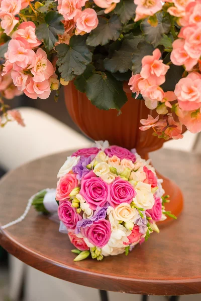 Wedding saturate pink rose bouquet of bride on table — Stock Photo, Image