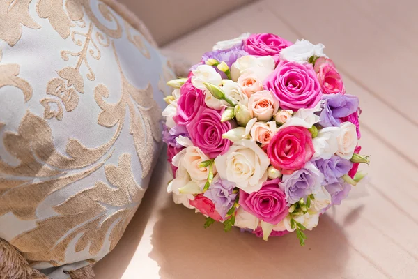 Wedding saturate pink rose bouquet of bride on sofa — Stock Photo, Image