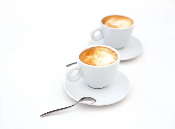 Two white cups of Cappuccino coffee with heart shaped milk foam — Stock Photo, Image