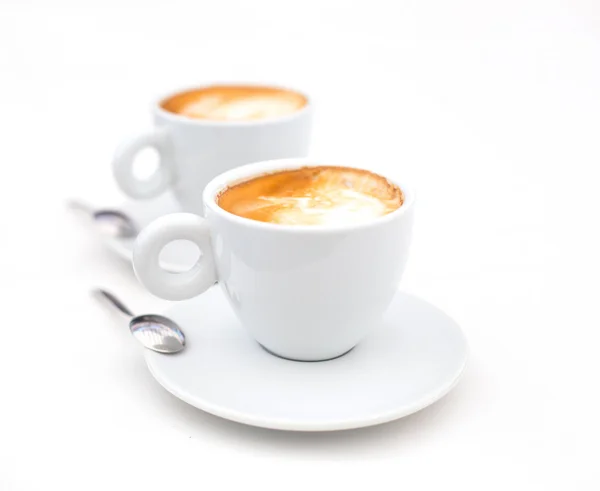 Twee witte kopjes koffie cappuccino met hartvormige melk schuim — Stockfoto