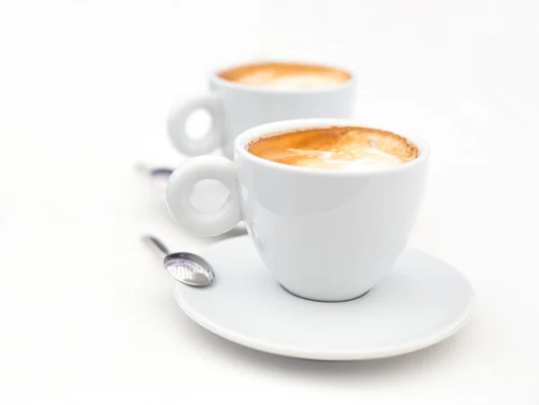 Two white cups of Cappuccino coffee with heart shaped milk foam — Stock Photo, Image