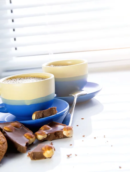 Dos tazas blancas de café capuchino con espuma de leche en forma de corazón — Foto de Stock