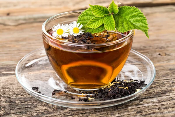 Skla šálek čaje Heřmánek květ a list máty na hnědý dřevěný — Stock fotografie