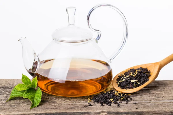 Glas waterkoker voor thee met muntblad op houten achtergrond — Stockfoto