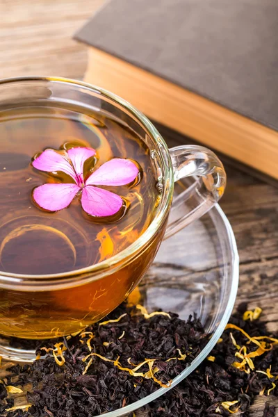 Thé tasse en verre avec fleur rose et feuille de menthe, sur pa en bois brun — Photo