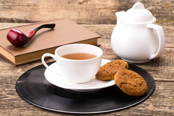 甜饼干、 书和烟草管木象牙茶杯 — 图库照片