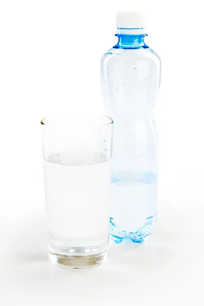 Bouteille d'eau avec plein verre sur fond blanc — Photo